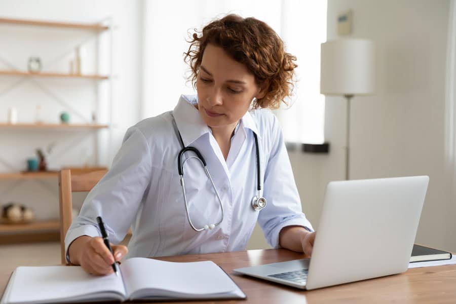 une femme medecin prenant des notes dans son carnet