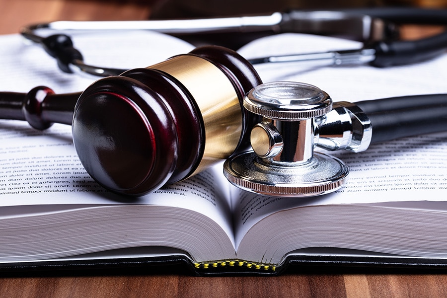 un marteau de la justice sur un livre medical