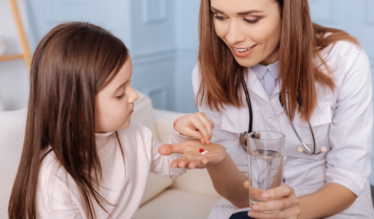 infirmiere donnant une pilule a une fille