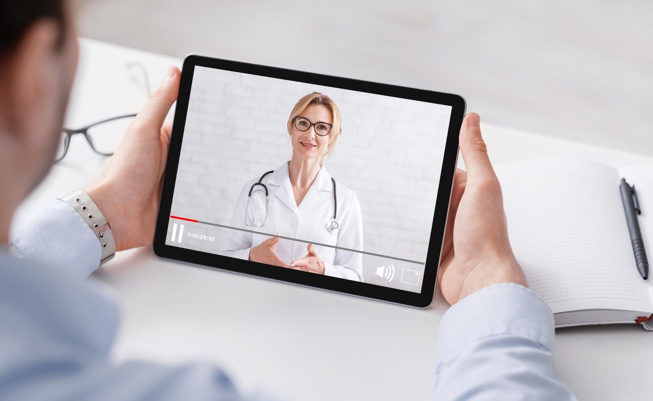 un homme regarde une vidéo médicale avec une femme médecin